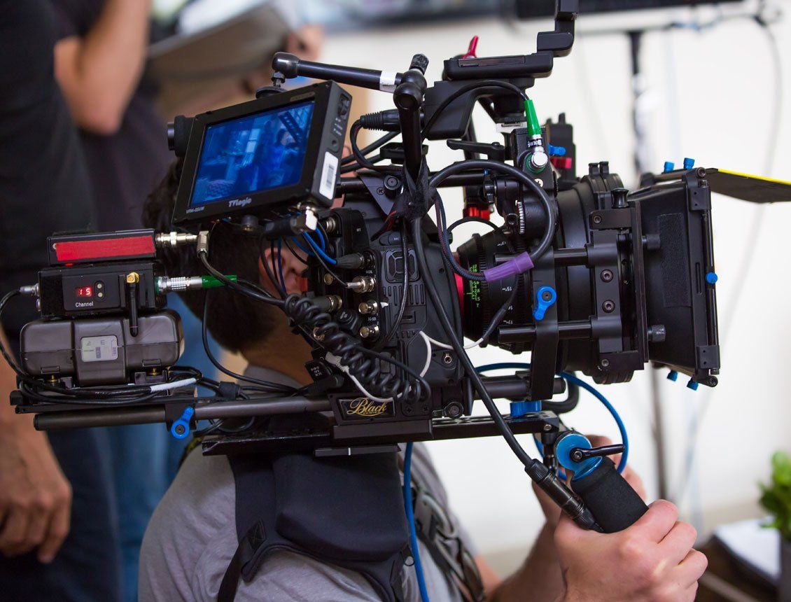 A man is holding a camera in front of his head.
