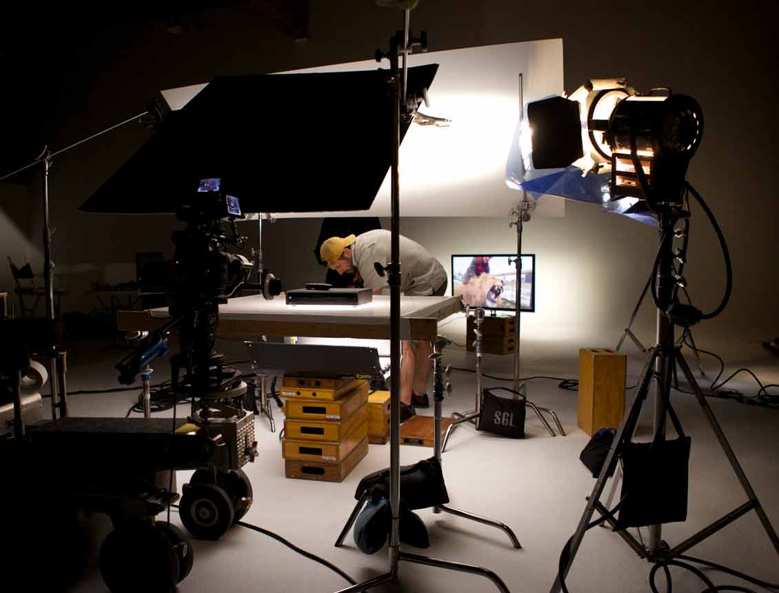A man is sitting at a table in a dark room with lots of lights
