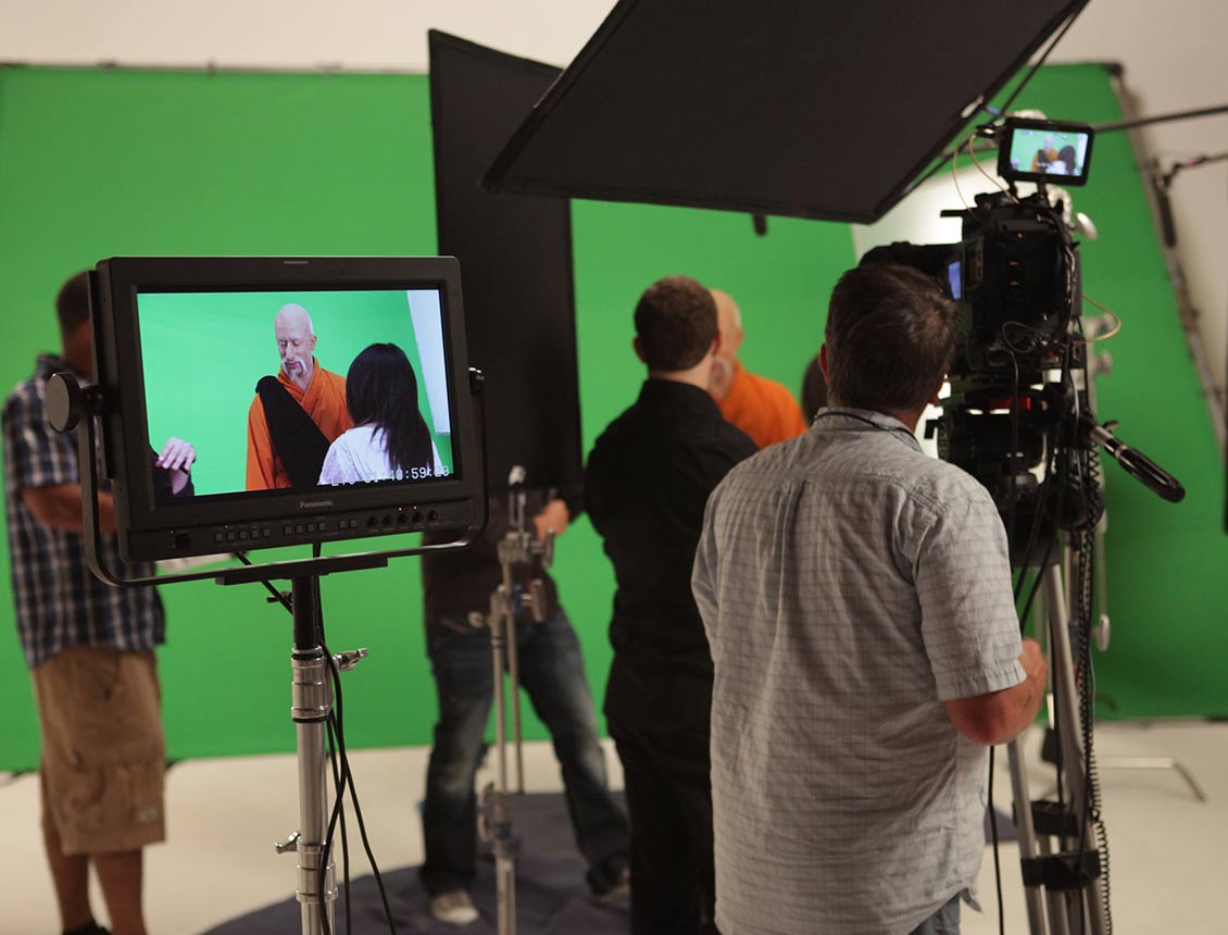 A group of people are standing in front of a green screen