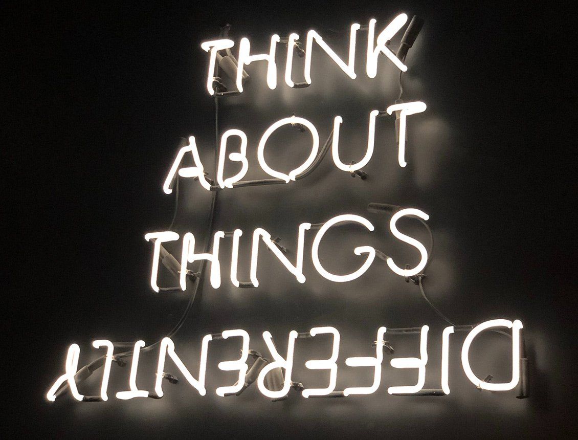A neon sign that says think about things differently