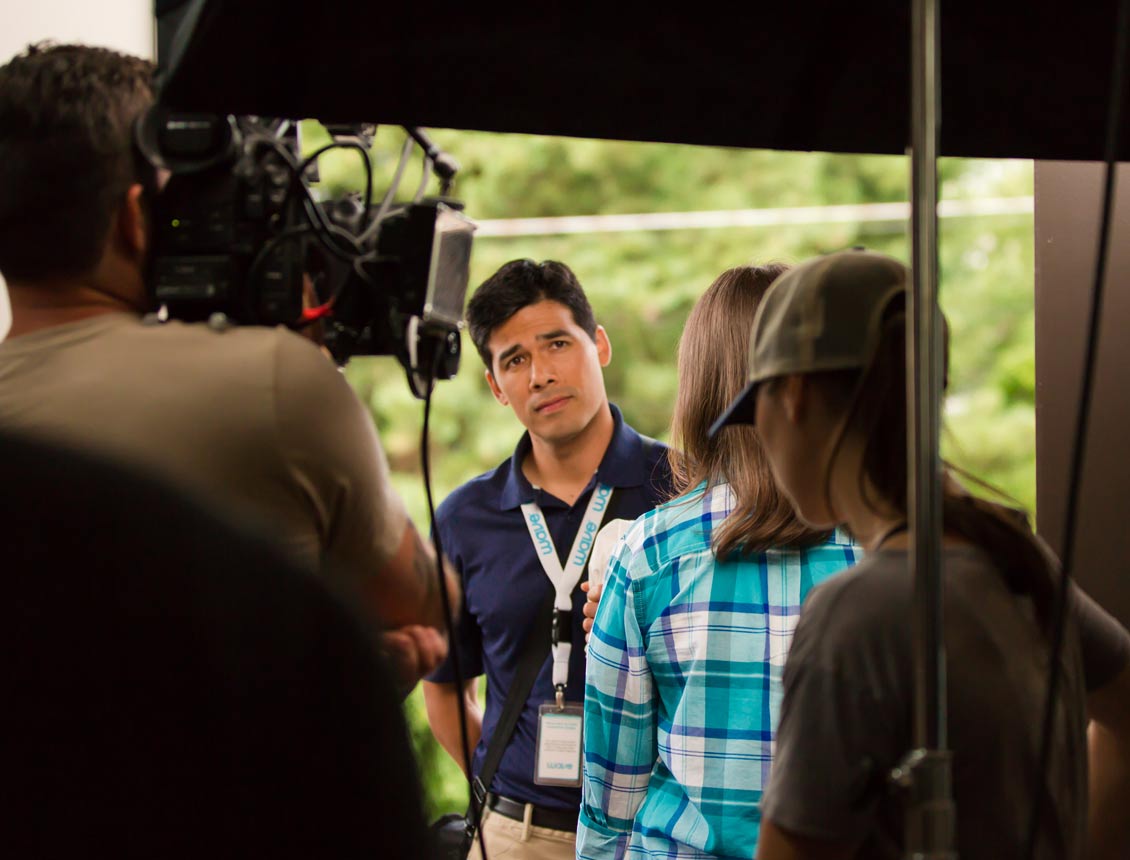 A group of people are standing in front of a camera.