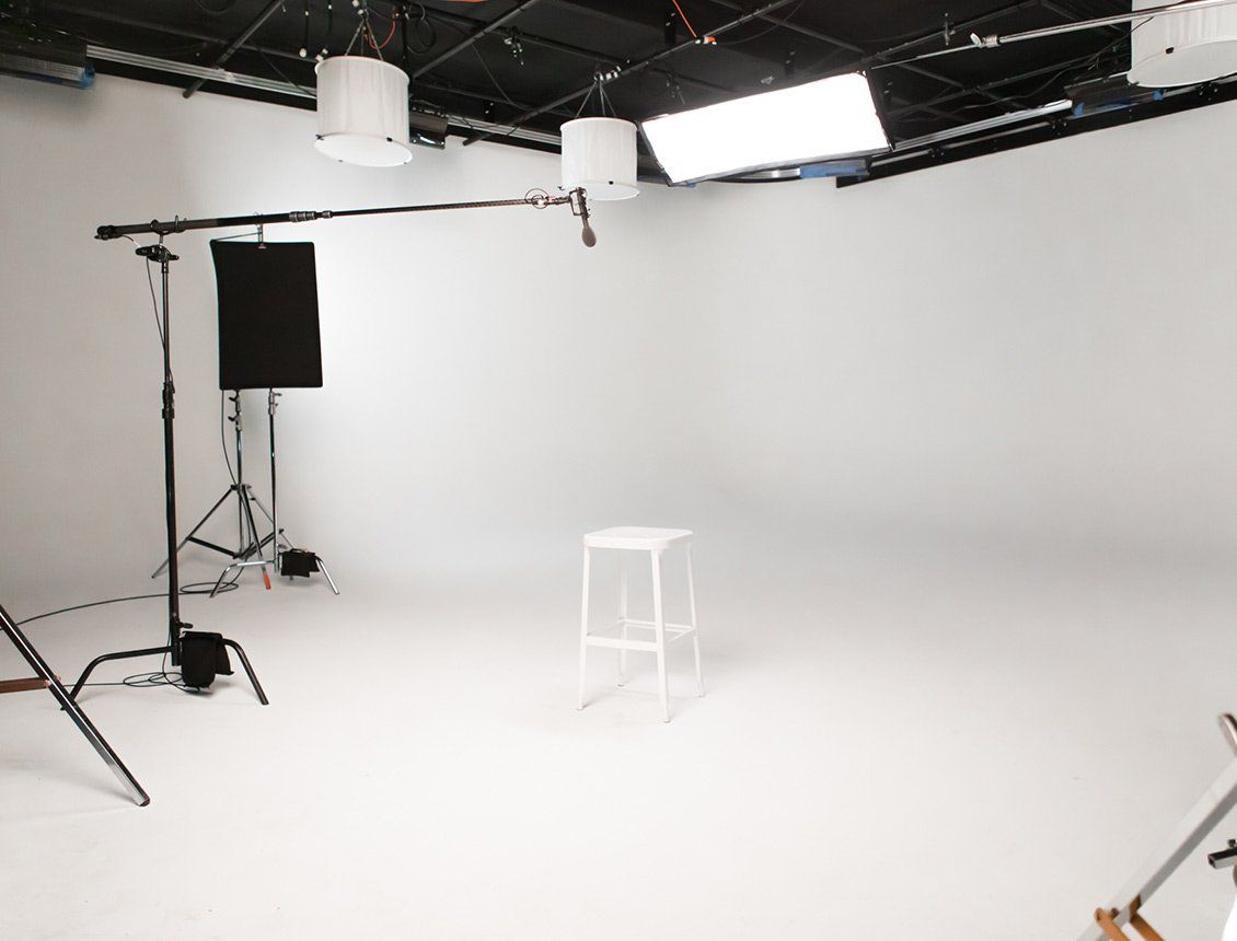 An empty photo studio with a stool and a microphone