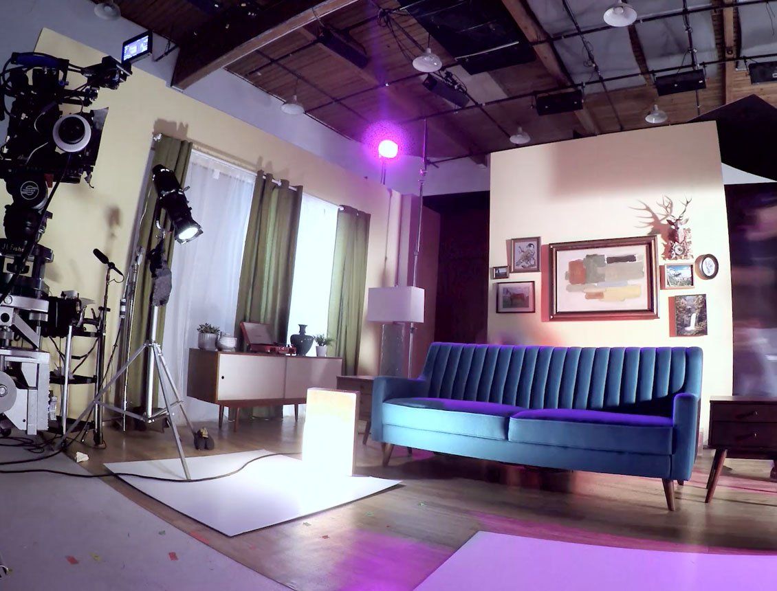 A living room with a blue couch and purple lights
