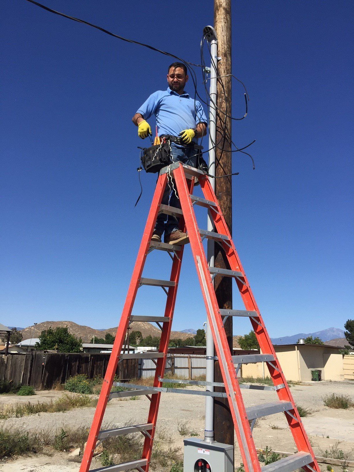 Man in a Ladder Repairing an Electrical Post — Riverside, CA — Volt Tech Electric