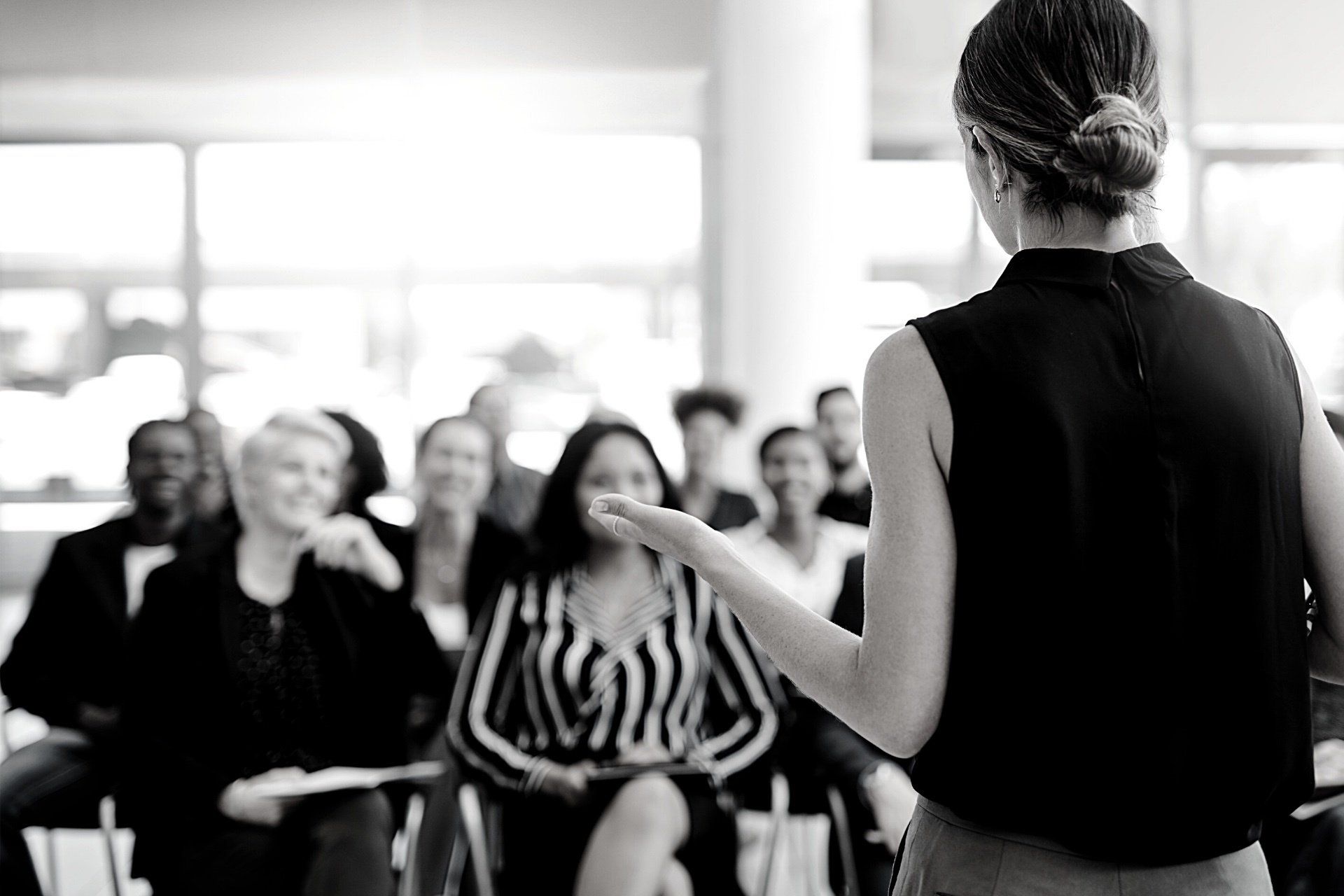 A woman is giving a presentation to a group of people.