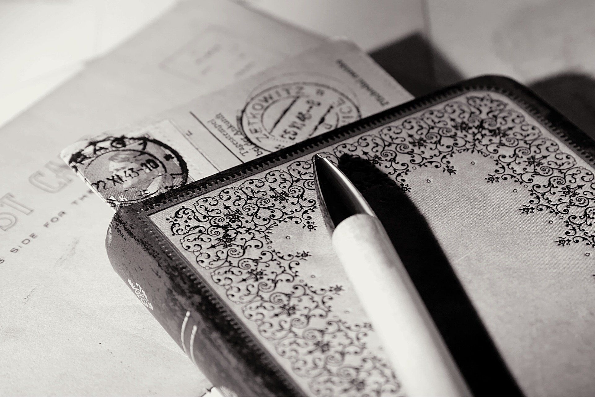A black and white photo of a pen on top of a book