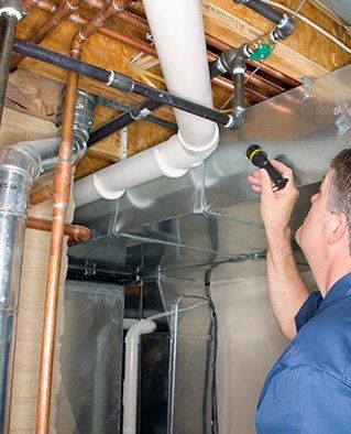 Plumbing Contractor — Plumber Looking Pipes in Kitchen in Antioch, CA