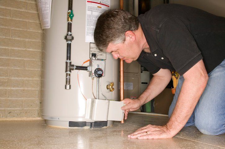 Tankless Water Heater — Man Working on Heater in Kitchen in Antioch, CA Tankless Water Heater — Man Working on Heater in Kitchen in Antioch, CA