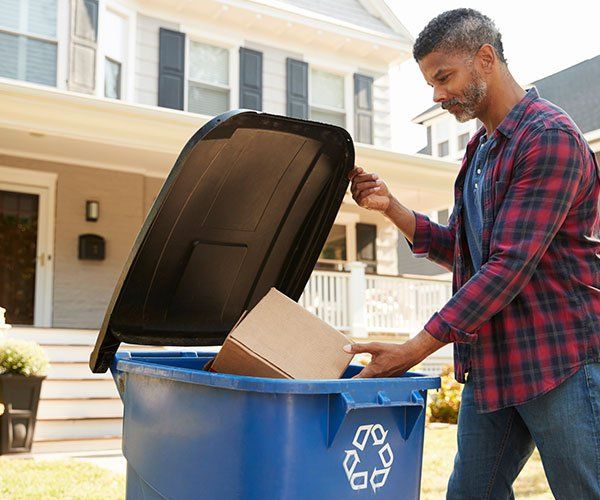 Man Throwing Trash — Storm Lake, IA — Garbage Hauling Service Inc Man Throwing Trash — Storm Lake, IA — Garbage Hauling Service Inc