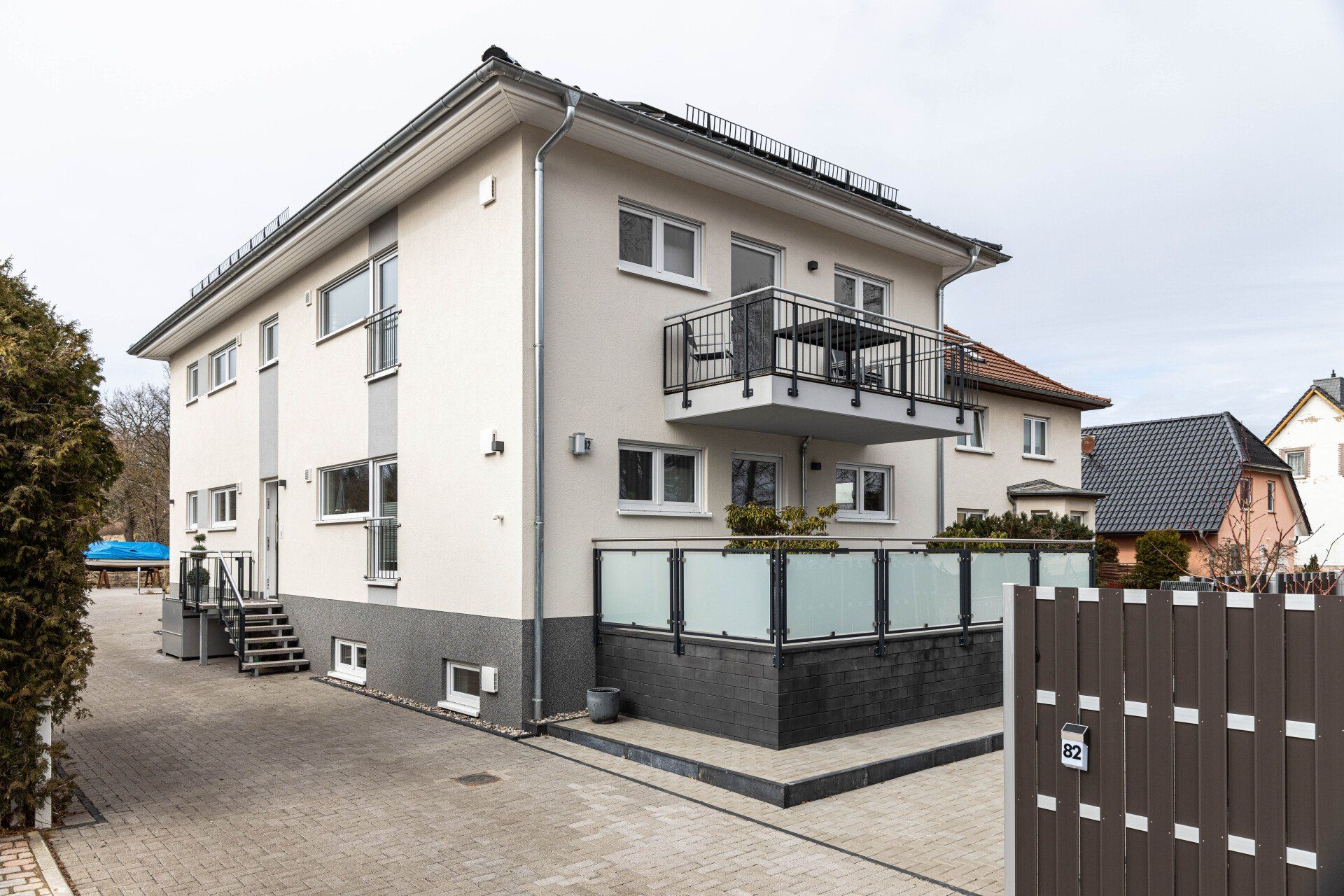 Ein großes weißes Haus mit einem Balkon und einem Zaun davor