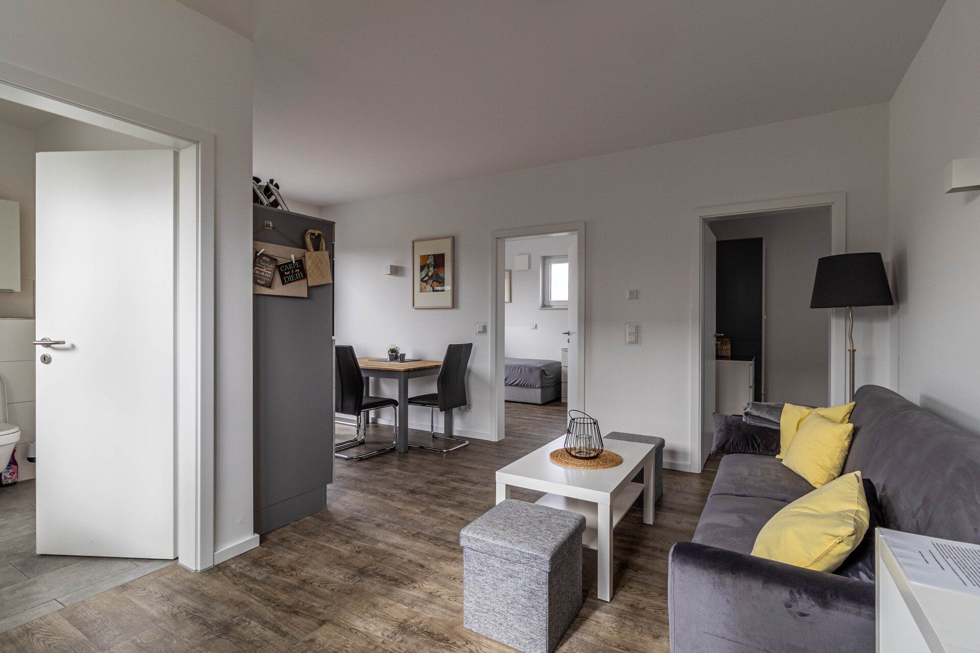 Ein Wohnzimmer mit Couch, Tisch und Stühlen.