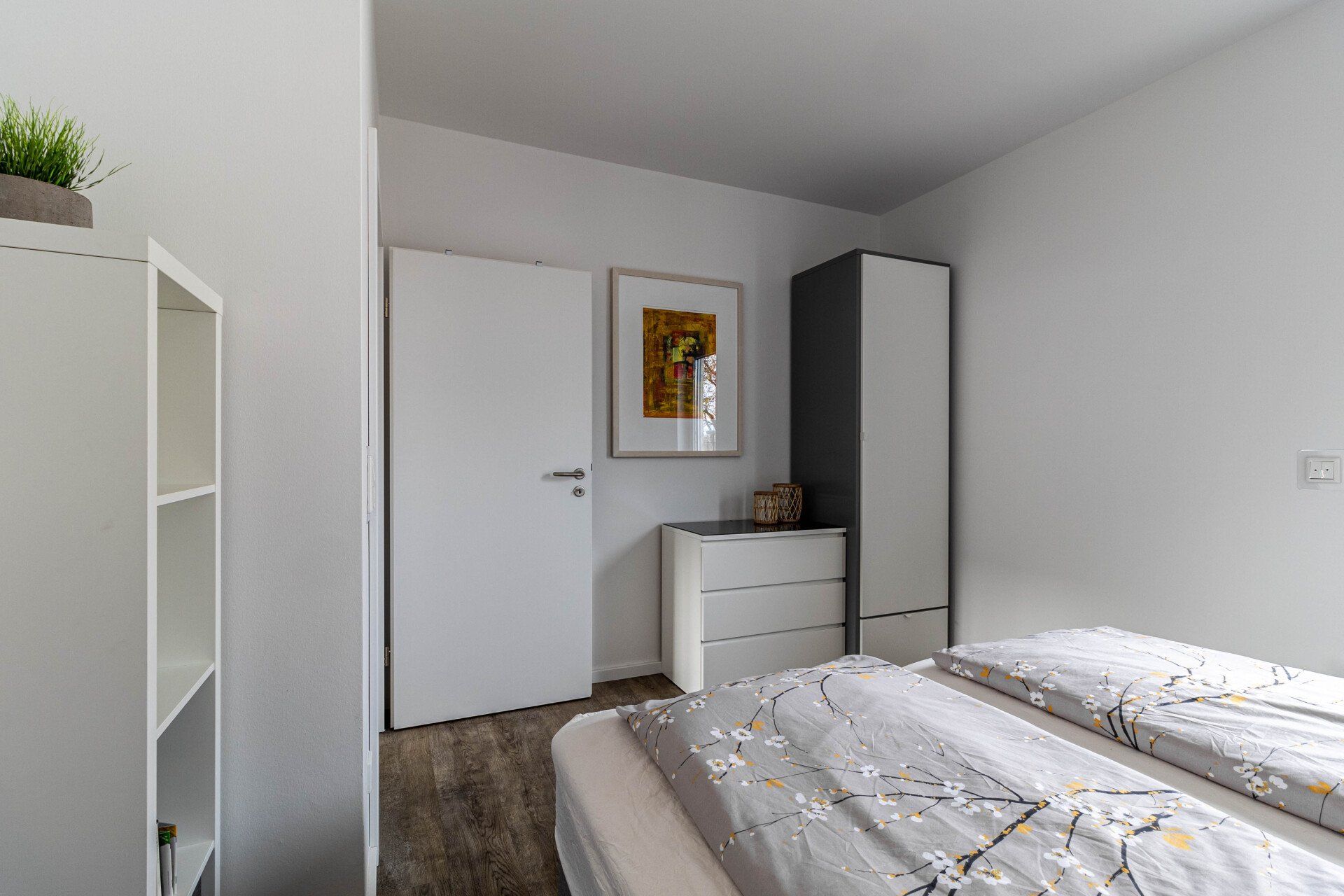 Ein Schlafzimmer mit Bett, Kommode und Kleiderschrank.