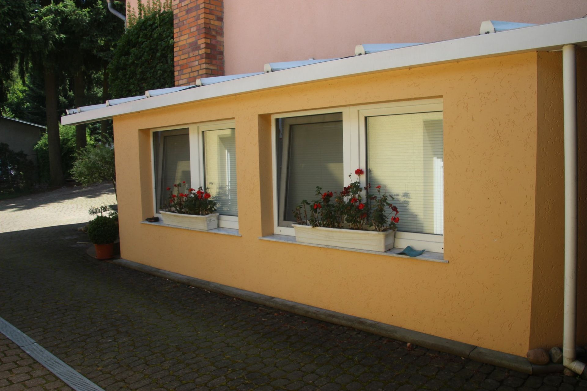 Zwei Fenster an der Seite eines Gebäudes mit Blumen darin