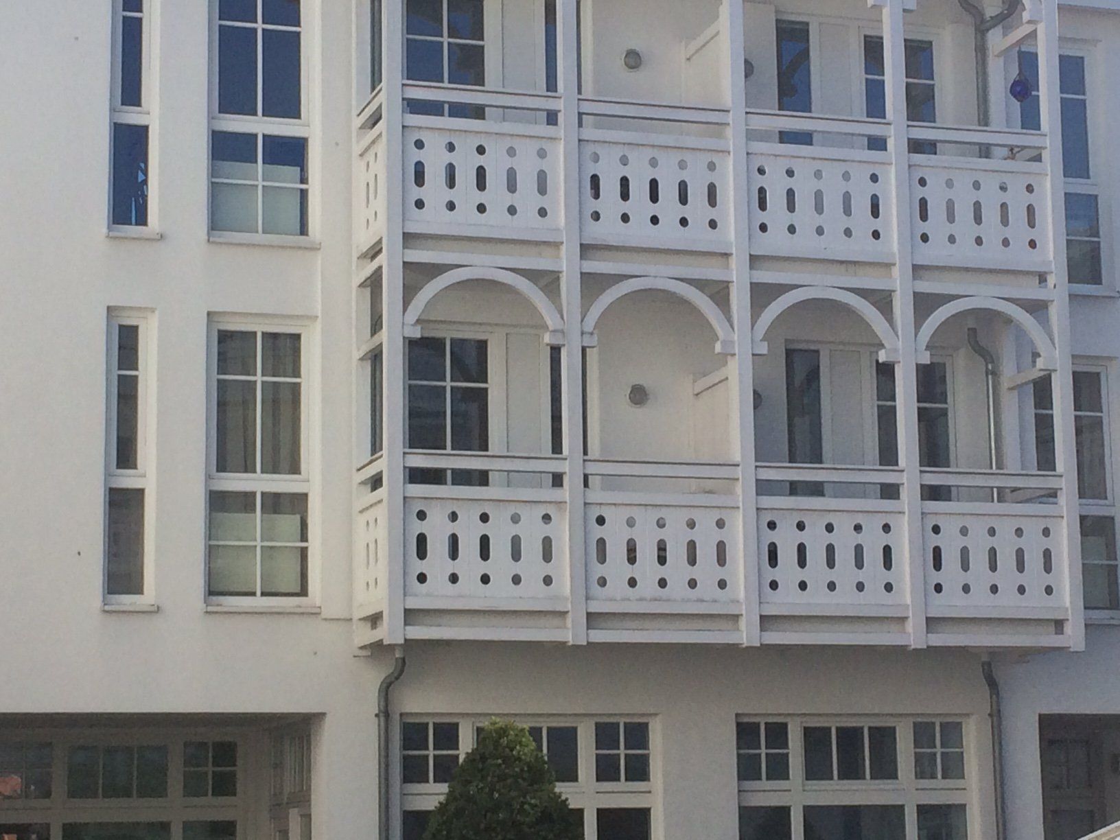 Ein weißes Gebäude mit vielen Fenstern und Balkonen