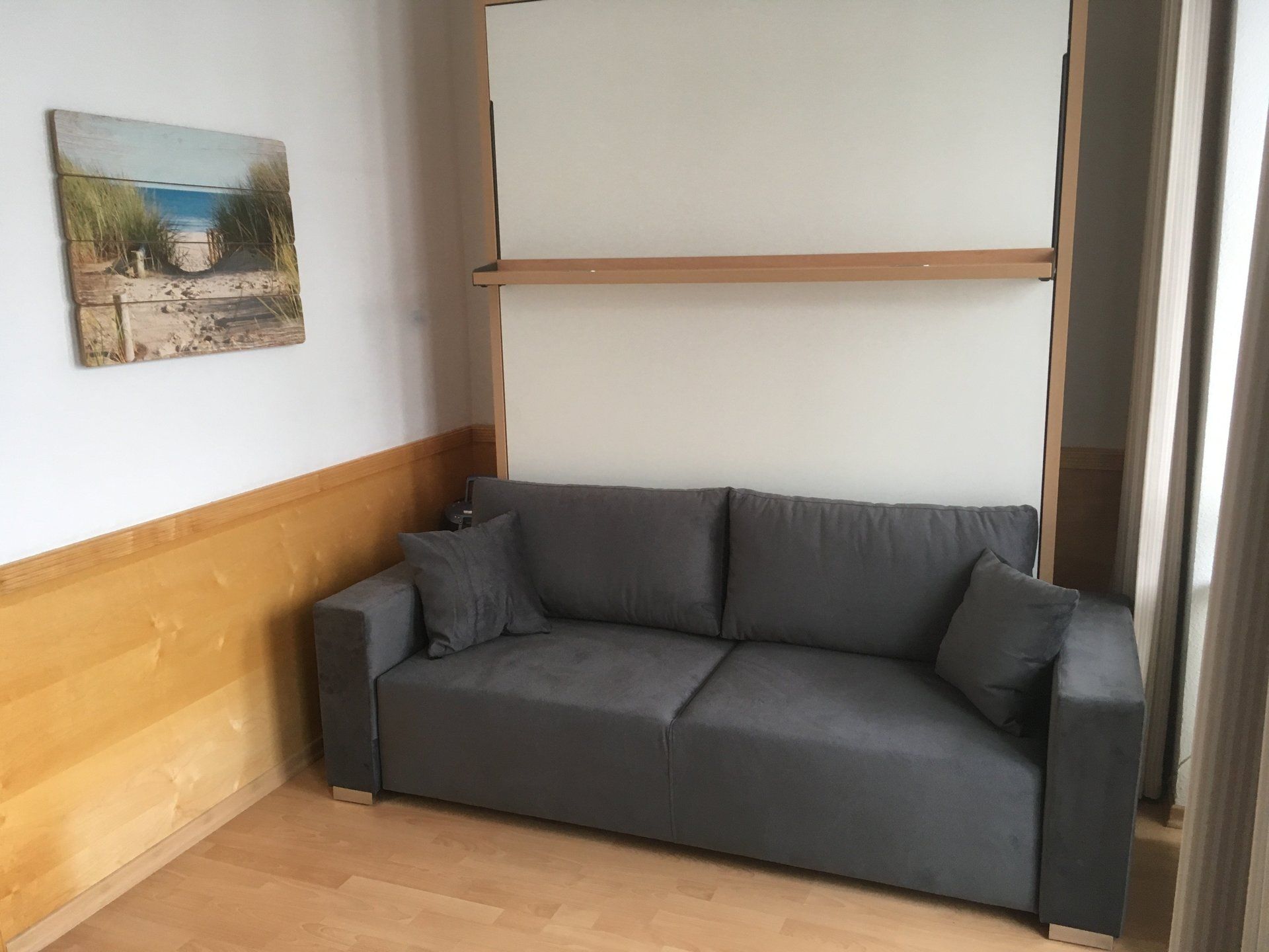 Ein Wohnzimmer mit einer Couch und einem Gemälde an der Wand.
