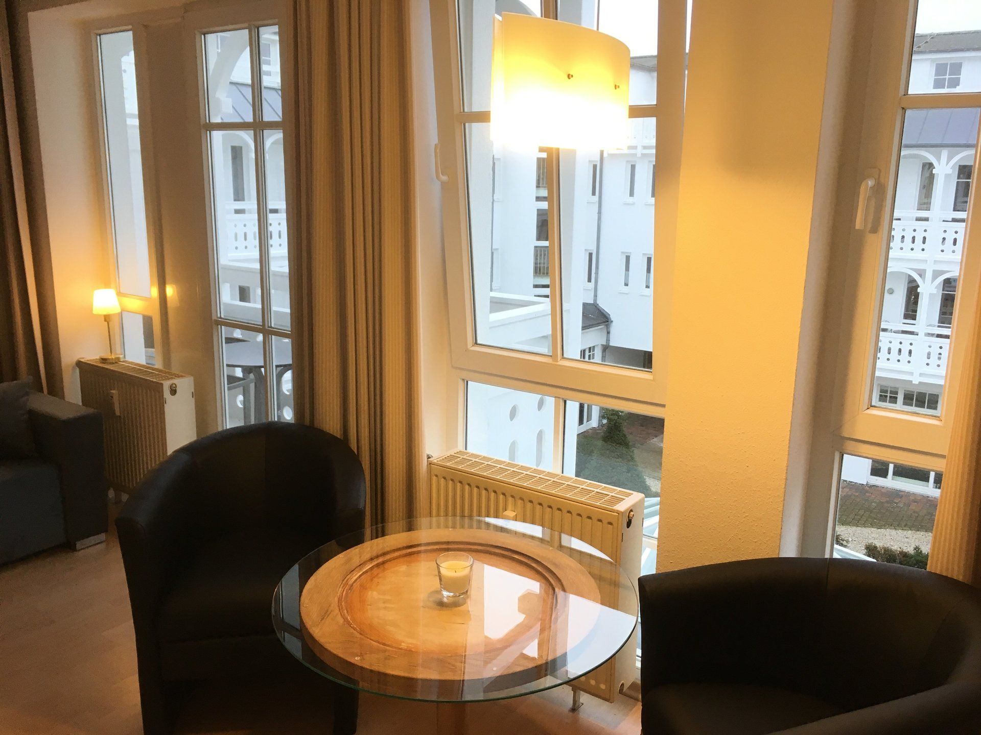 Ein Wohnzimmer mit zwei Stühlen und einem Tisch vor einem Fenster.