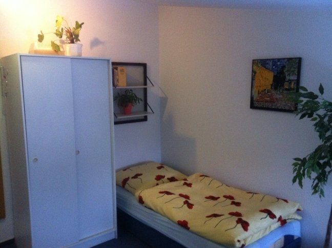 Ein Schlafzimmer mit einem Einzelbett und einem Gemälde an der Wand