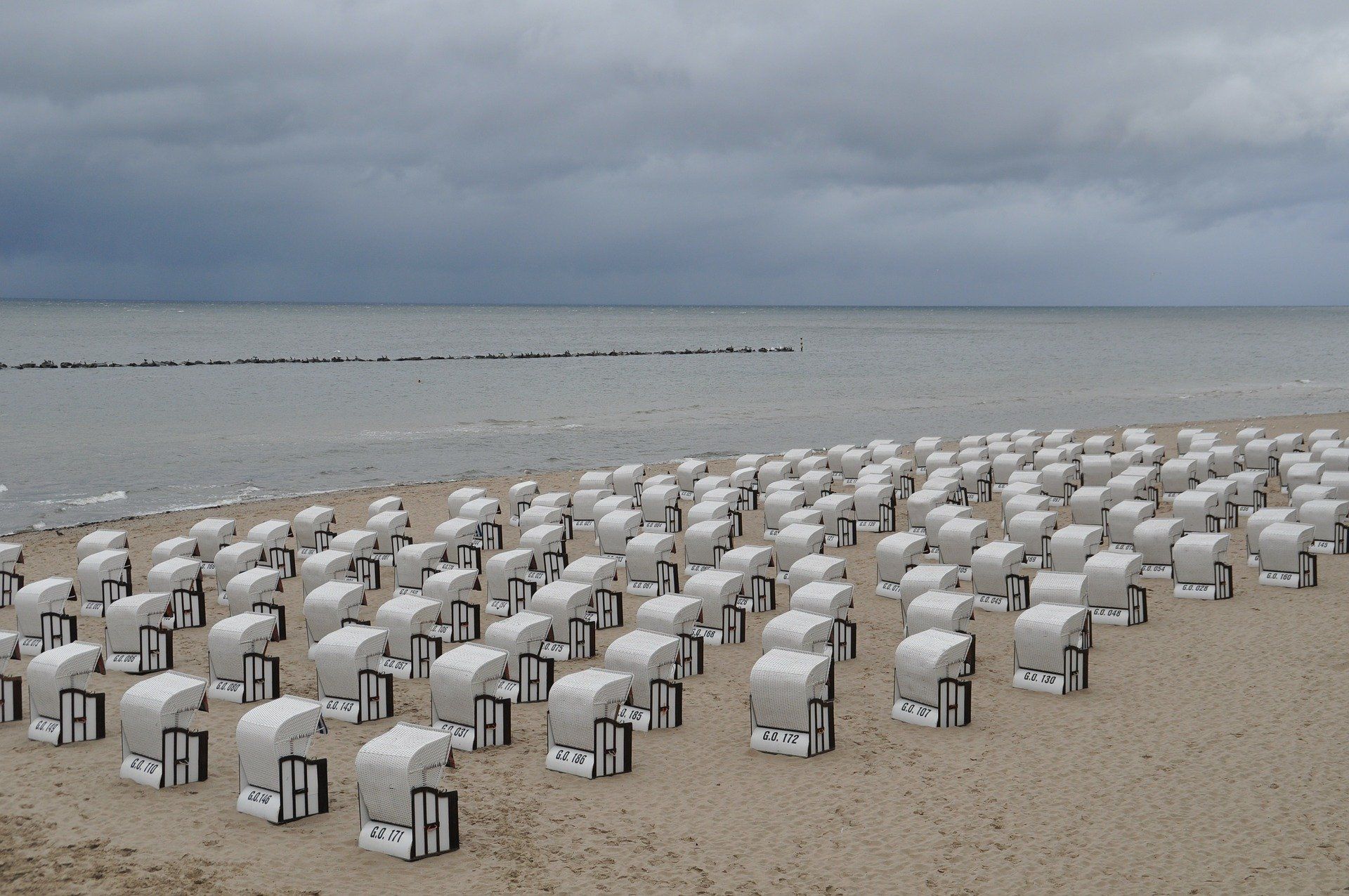 Ein Strand mit vielen weißen Stühlen darauf