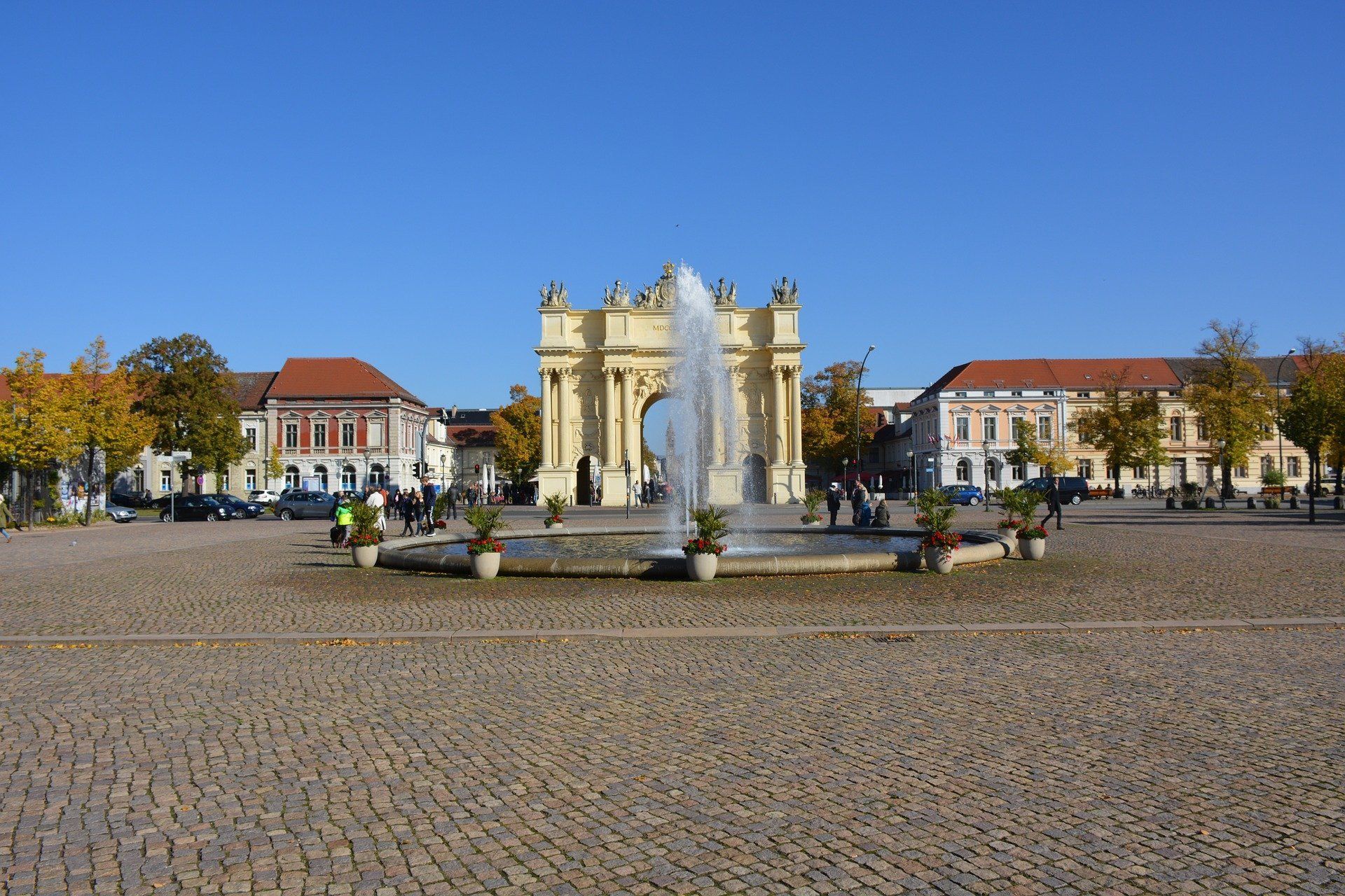 Ein Brunnen in der Mitte eines gepflasterten Platzes mit Gebäuden im Hintergrund