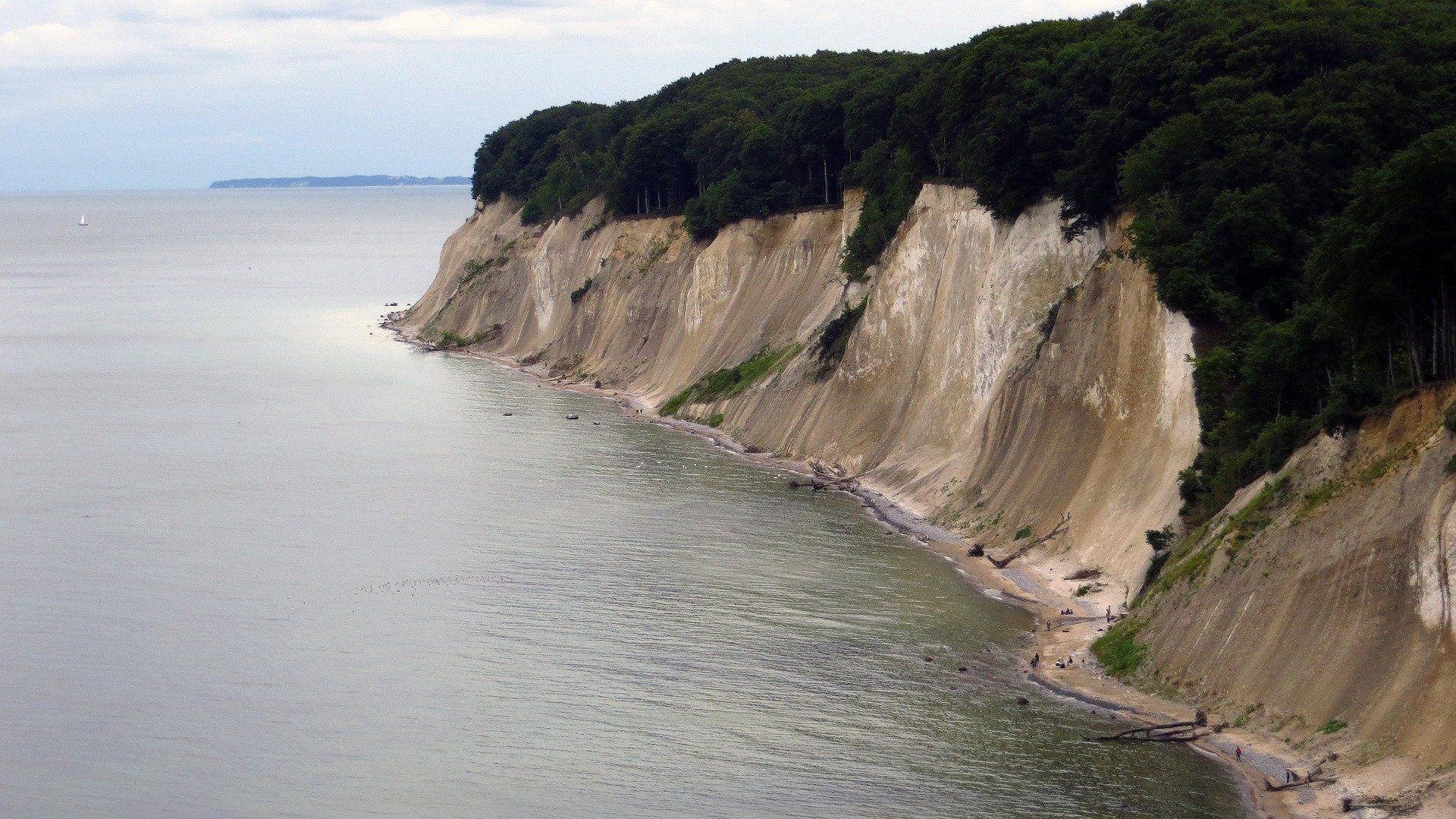 Eine Klippe mit Blick auf ein Gewässer mit Bäumen darauf
