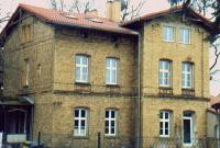 Ein großes Backsteingebäude mit einem roten Ziegeldach und vielen Fenstern.