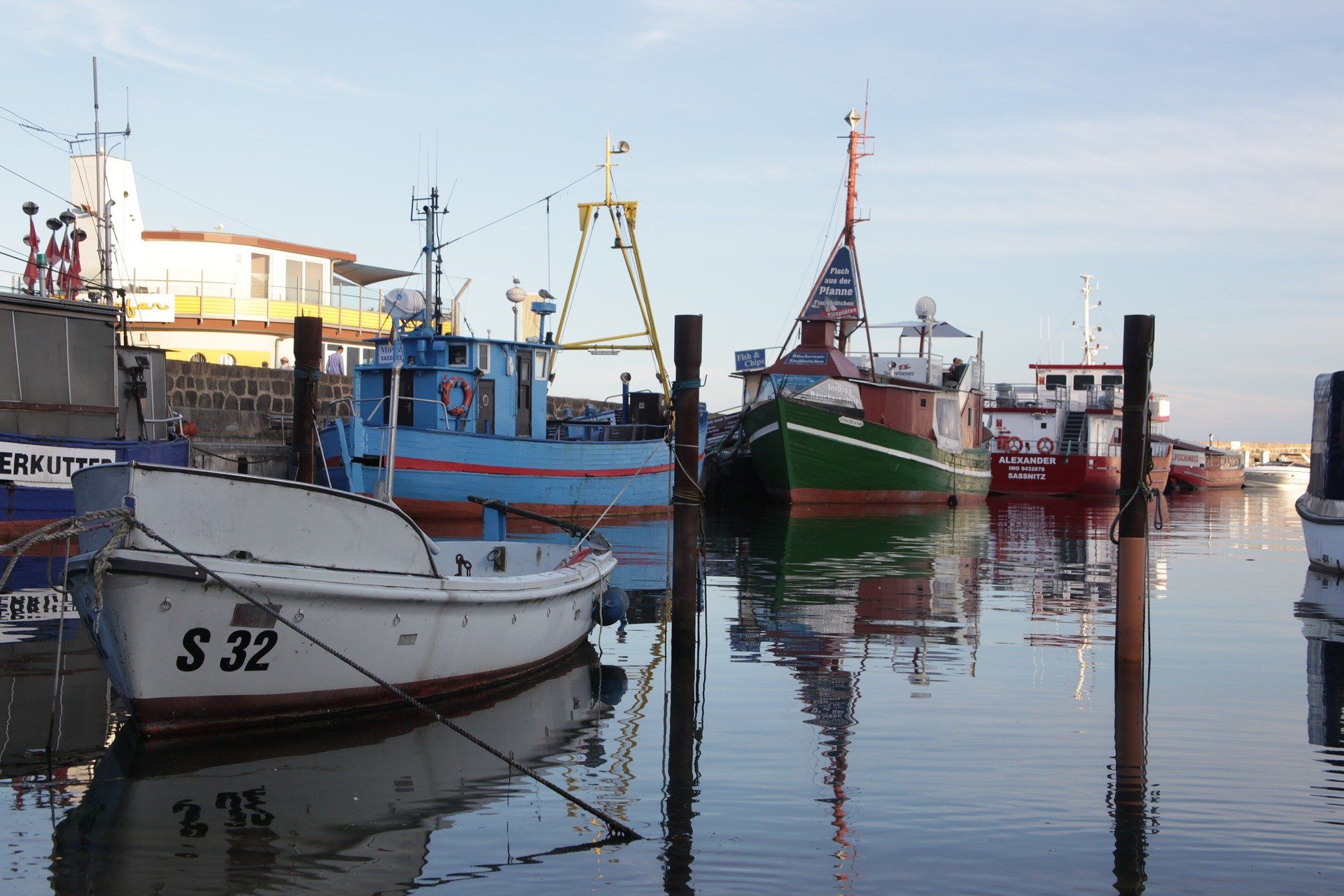 Mehrere Boote liegen in einem Hafen vor Anker und eines davon trägt die Nummer 32