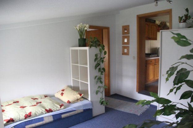 Ein Schlafzimmer mit einem Einzelbett und einem weißen Regal