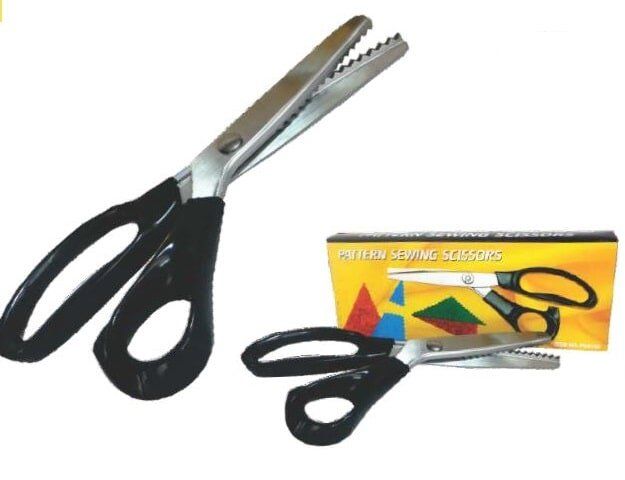 Black-handled pinking scissors with serrated blades, shown beside their colorful retail package.