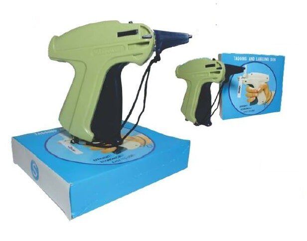 Green hot glue gun with cord on a blue box, shown with its packaging box nearby