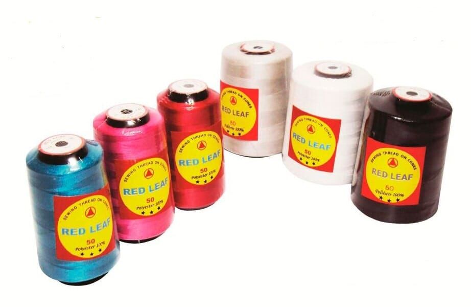 Spools of colorful thread or yarn arranged in a row on a white background