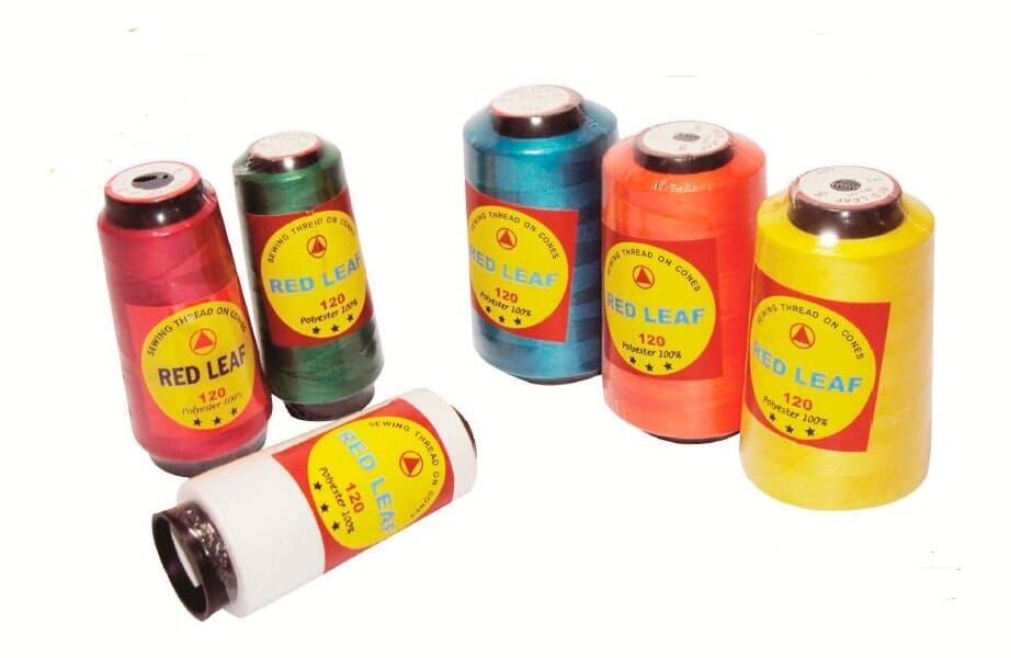 Several colorful thread spools on a white background, with one spool lying on its side