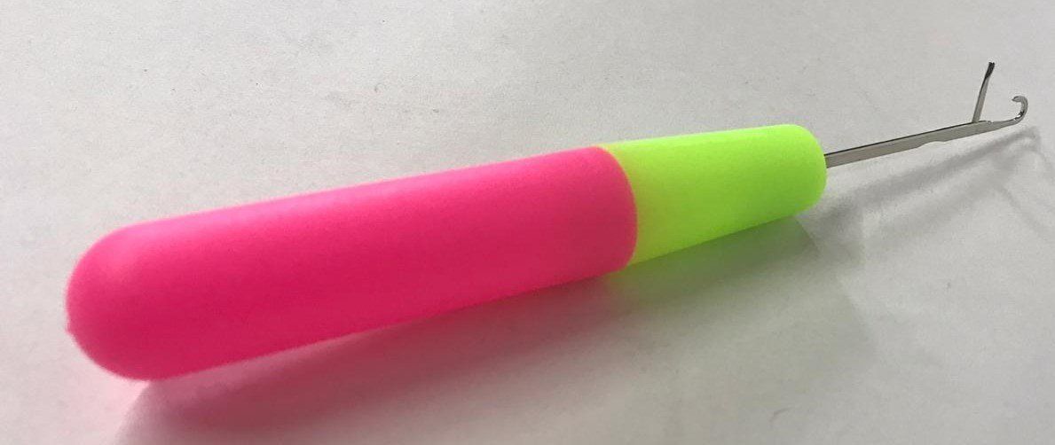 Pink and green plastic tool with a thin metal wire attached to the end