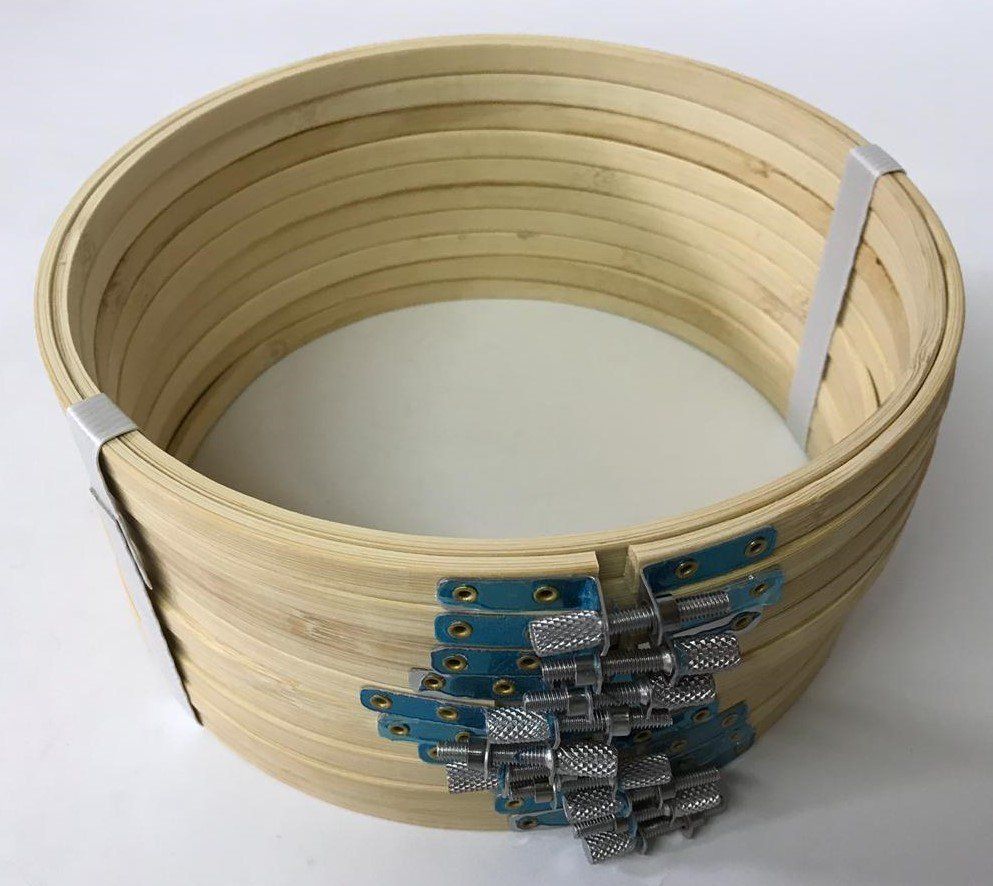 Coiled beige wooden slat basket with metal hinges and clips, viewed from above