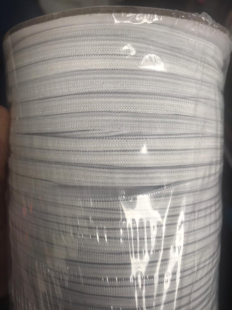 Stack of white coiled cable wrapped in clear plastic packaging