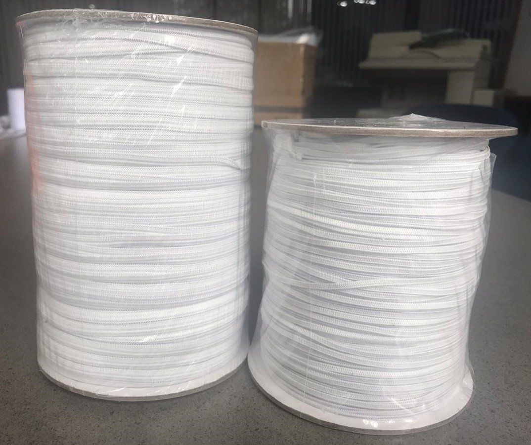 Two large stacks of white paper plates in a warehouse or storage area.