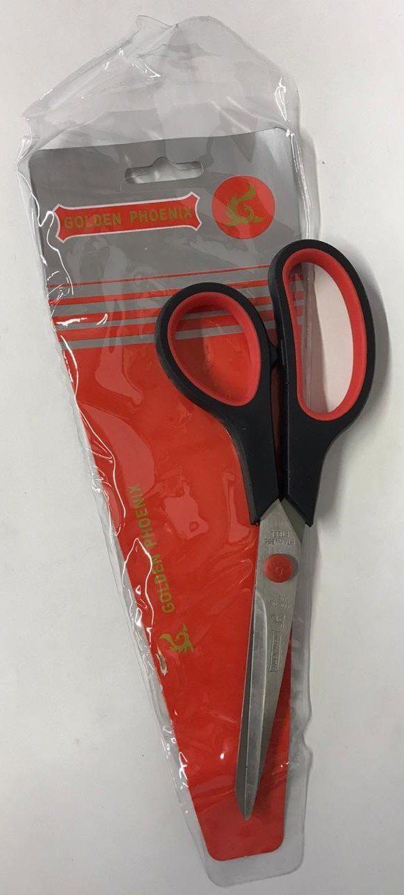 Black-handled scissors in clear plastic packaging on a red backing card.