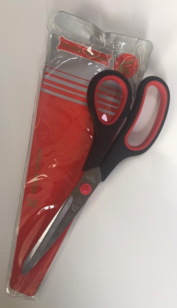 Red and black scissors in clear plastic packaging with red fabric or material inside.