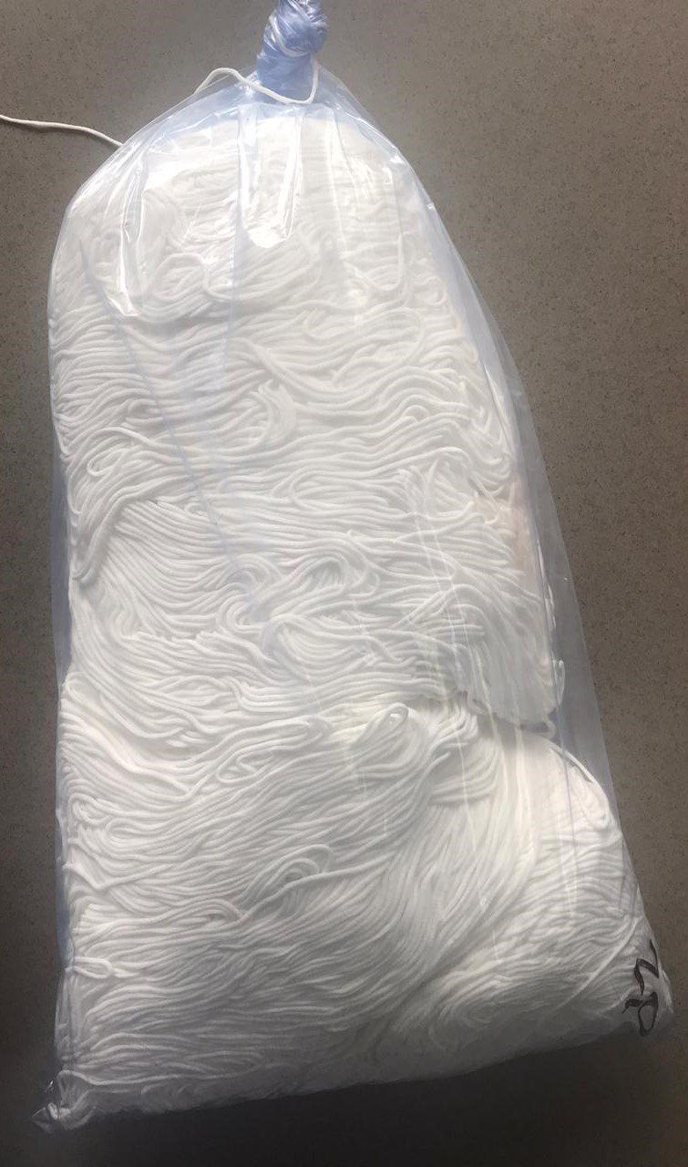 Clear plastic bag filled with white disposable gloves or hairnets
