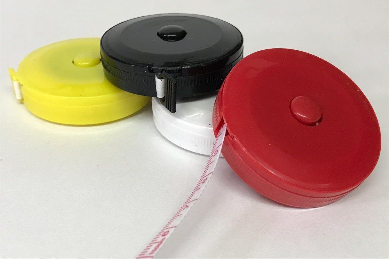 Three colorful retractable tape measures: yellow, black and white, and red.