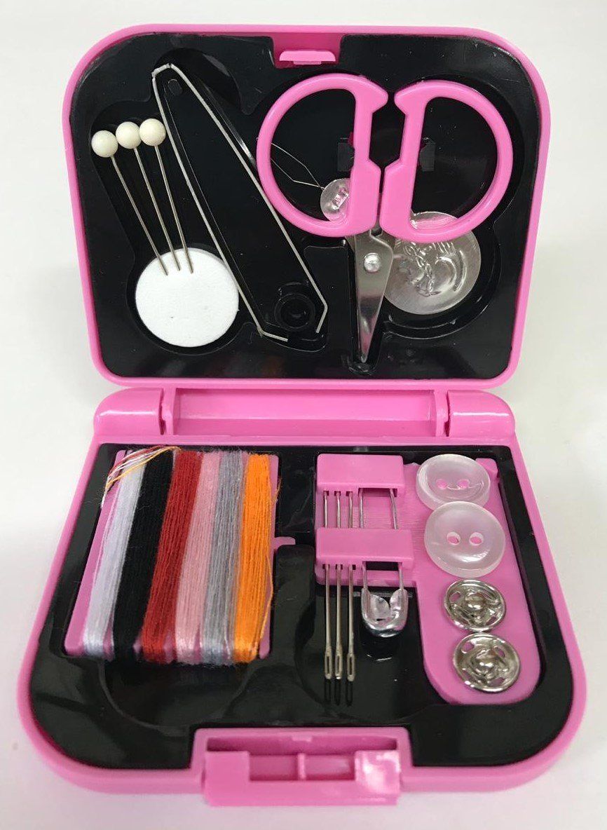 Pink sewing kit open with scissors, needles, thread, buttons, and thimble in a black case