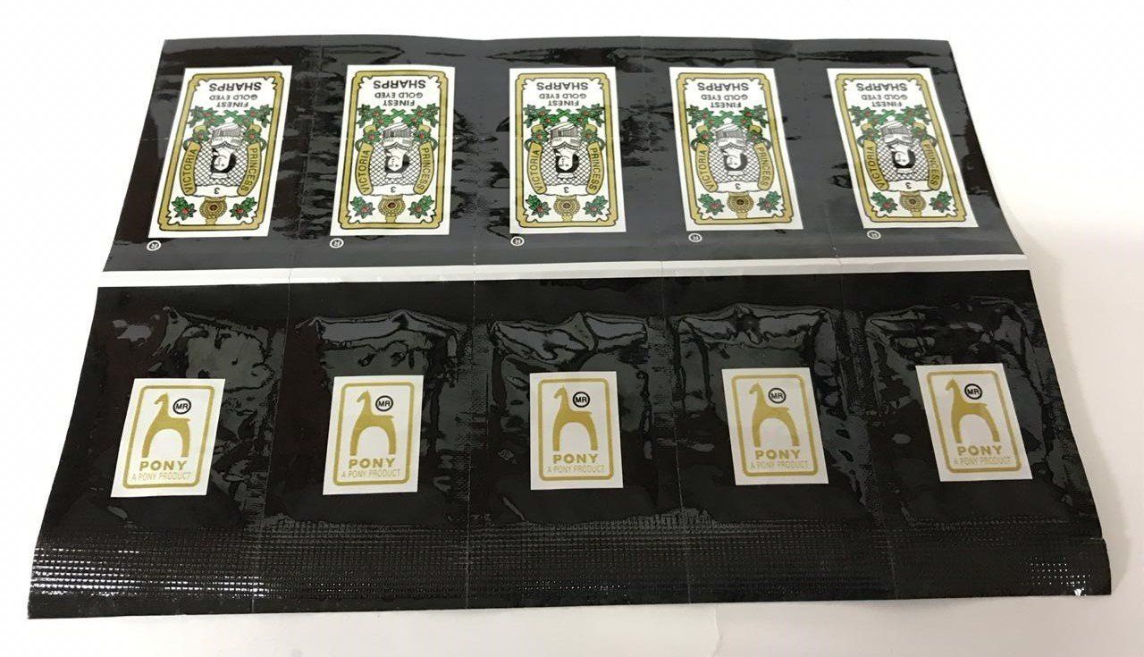 Opened jewelry display case with several gold-toned necklaces or pendants on black velvet lining