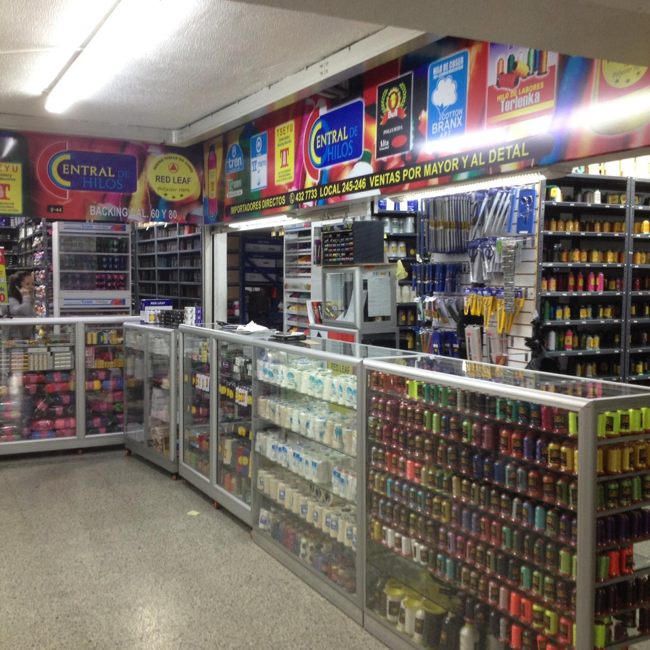 Convenience store aisle with glass display cases, shelves of snacks and drinks, and colorful brand signs
