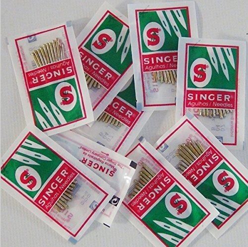 Several Singer sewing machine needle packets scattered on a light surface.