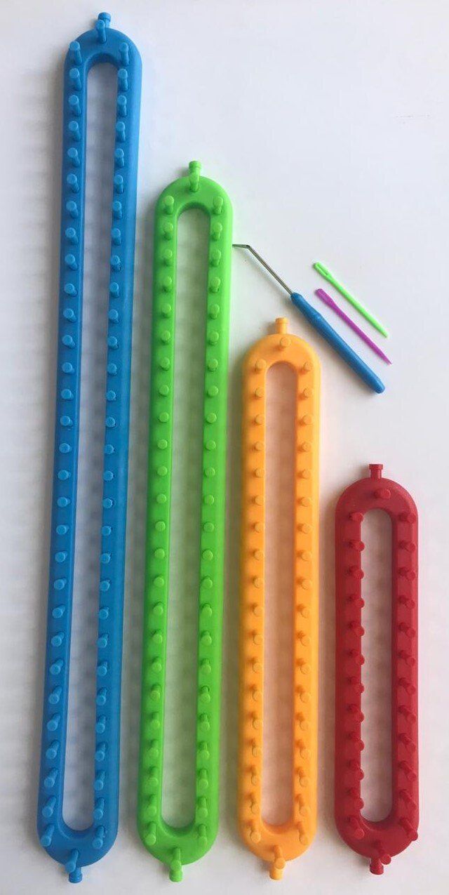 Four colorful plastic ring-shaped rulers and small colored sticks on a white background