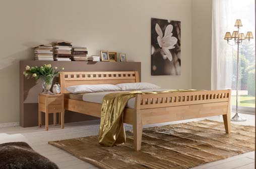 Holzbettrahmen in einem Schlafzimmer mit Nachttisch, Kunstwerk und Teppich.