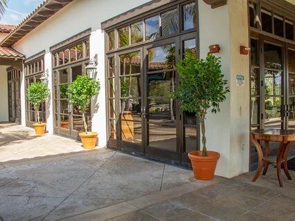 A building with a lot of windows and potted plants in front of it