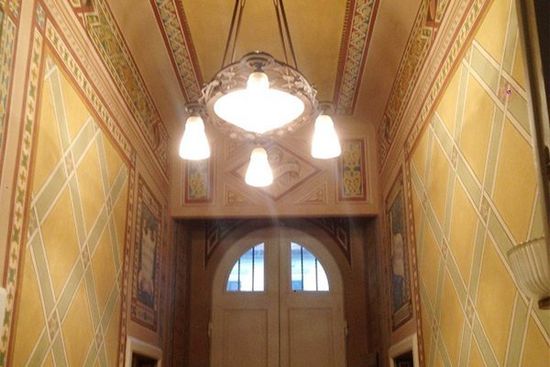 interno di una casa con un lampadario da soffitto e delle piastrelle arancioni e a mosaico