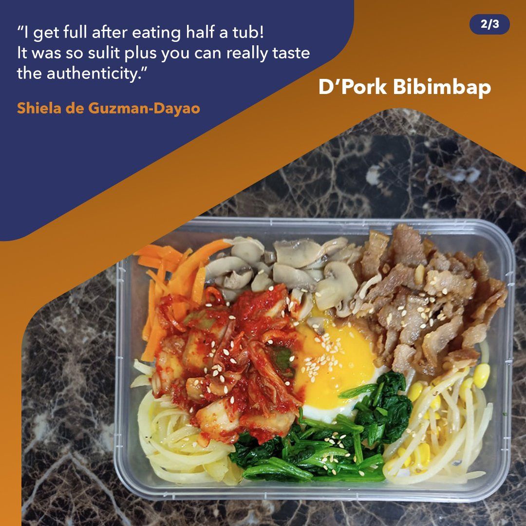 D’Pork Bibimbap in a clear container with rice, pork, vegetables, and a fried egg on a dark table