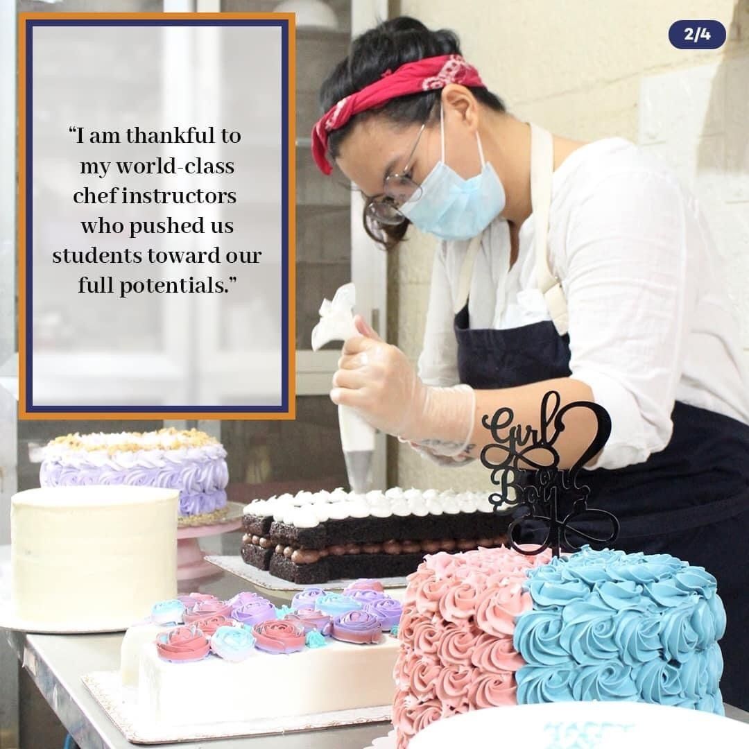 Person in mask decorating a cake beside colorful frosted cakes and a thank-you sign at a dessert table