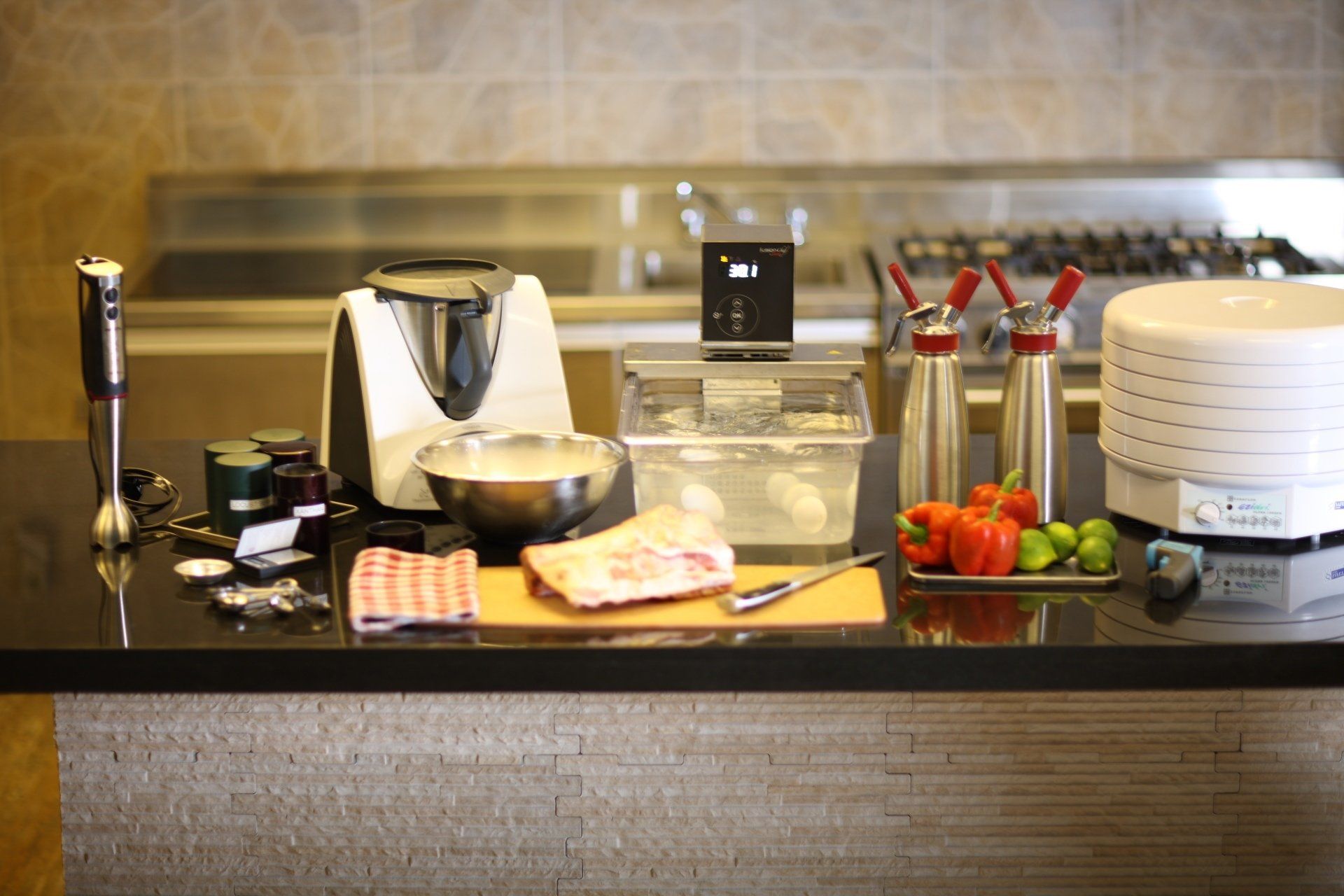 Countertop buffet with bread, pastries, fruit, coffee maker, and utensils in a kitchen dining area